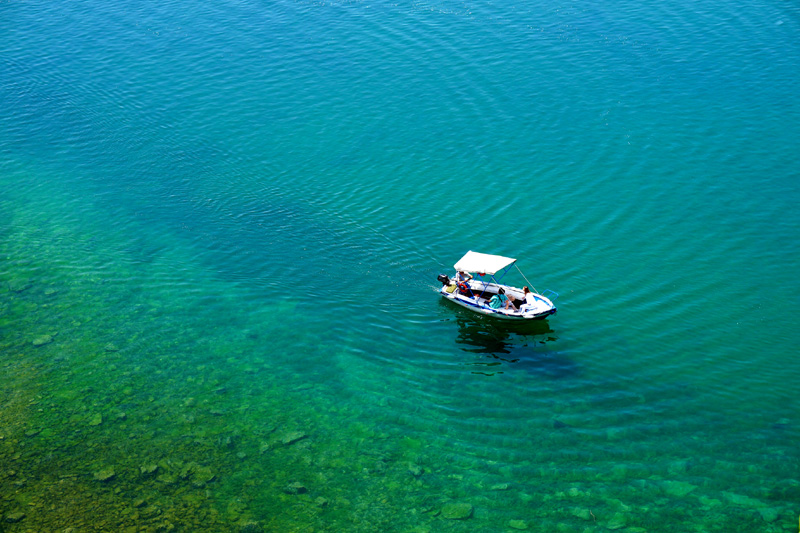 A boat in Lake Ohrid in clear turquoise water, North Macedonia