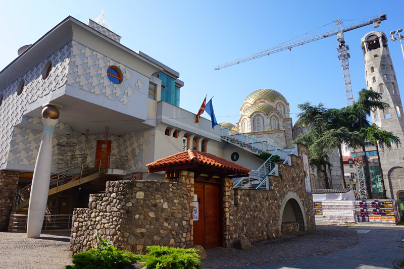 Weird assortment of buildings - the Mother Teresa Memorial Building and Orthodox church, Skopje, North Macedonia