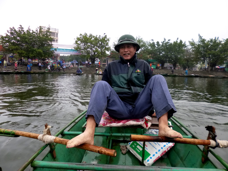 Our tour guide rowing down the river using his feet in Ninh Binh, Vietnam