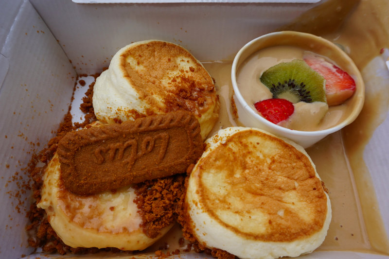 Fluffy Japanese pancakes at Koko House, Glasgow, Scotland. There's a separate side dish of Biscoff sauce with fruit, which has spilled everywhere.