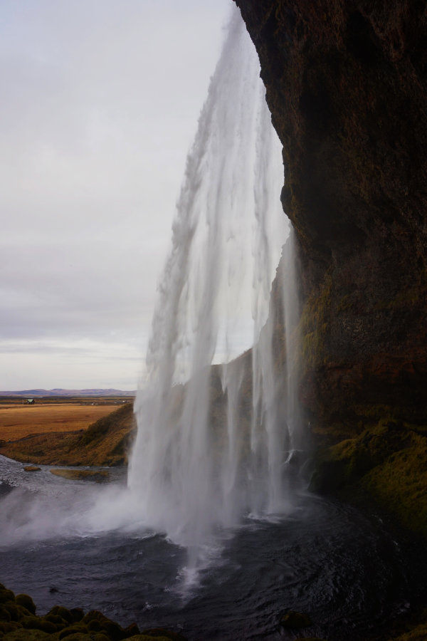 Walking behind Sjeljalandsfoss waterfall, Iceland