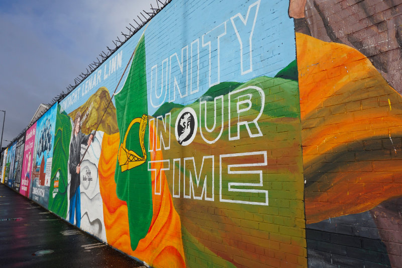 Mural saying "unity in our time" with the Irish flag, Belfast, Northern Ireland