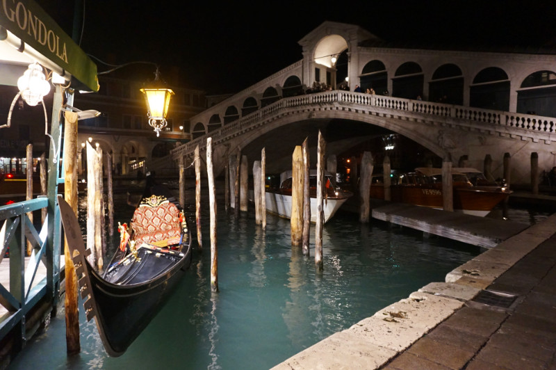 Rialto Bridge at night with gondola, Venice, Italy
