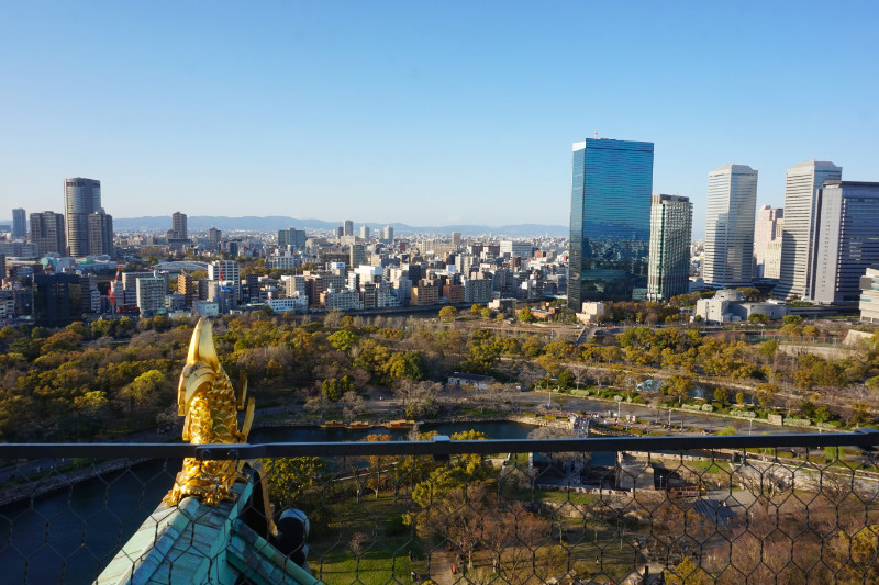 View from Osaka Castle, Japan. One of the skyscrapers is reflecting the city and hills.