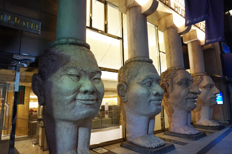 Face pillars outside the Dotonbori Hotel, Dotonbori, Osaka, Japan. There are four heads with little feet. Whatever you're imagining, it's probably crazier.