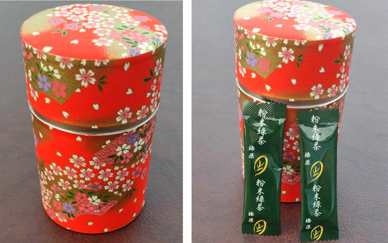 Matcha tea tin from Japan. The tin is red with floral patterns on it and petals falling. Second photo has two sachets of matcha tea.