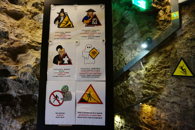 Entrance to the tunnels at Kiek in de Kok, Tallinn, Estonia. There's a sign with 6 warnings on it, all "portrayed" by different types of people who have occupied the tunnels - punks, people wearing gas masks, a ghost!