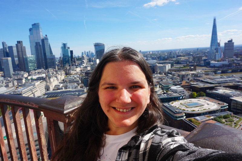 Me at the top of St Paul's, London. I am facing the camera, and behind me to the left are all the new skyscrapers of London. To the right is the Shard and you can see Tower Bridge poking out of my head.