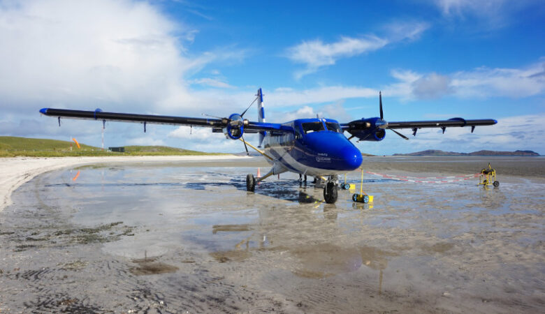 Twin Otter Loganair plane on the beach in Barra, Scotland
